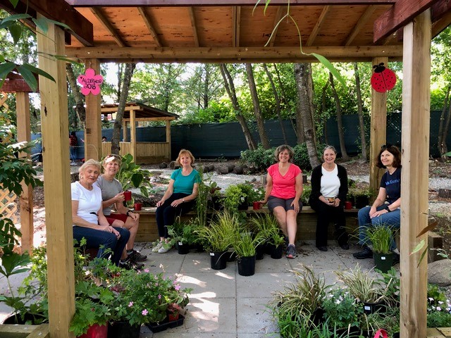 Garden Club members sitting under a gazebo.