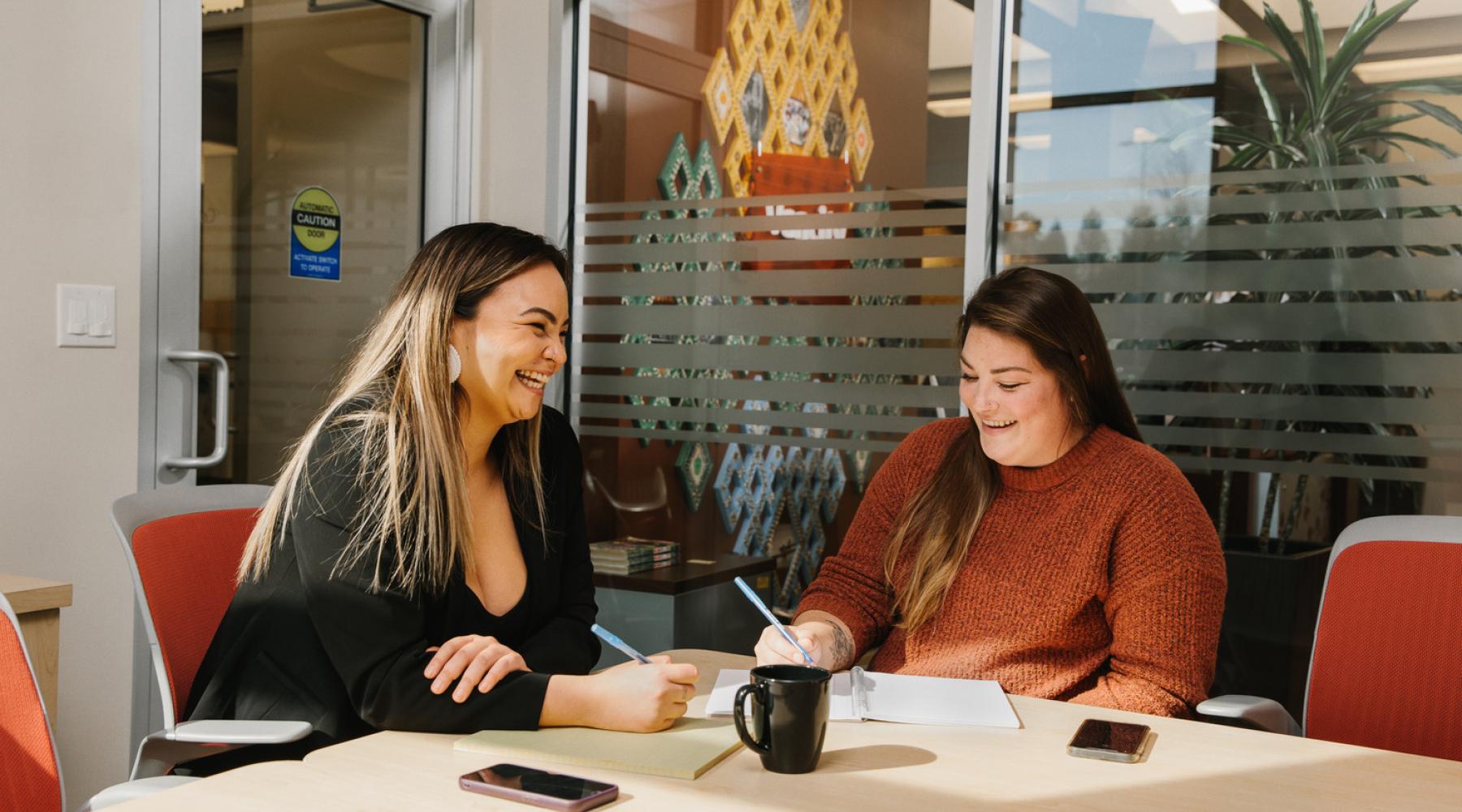 two women sitting in an office 